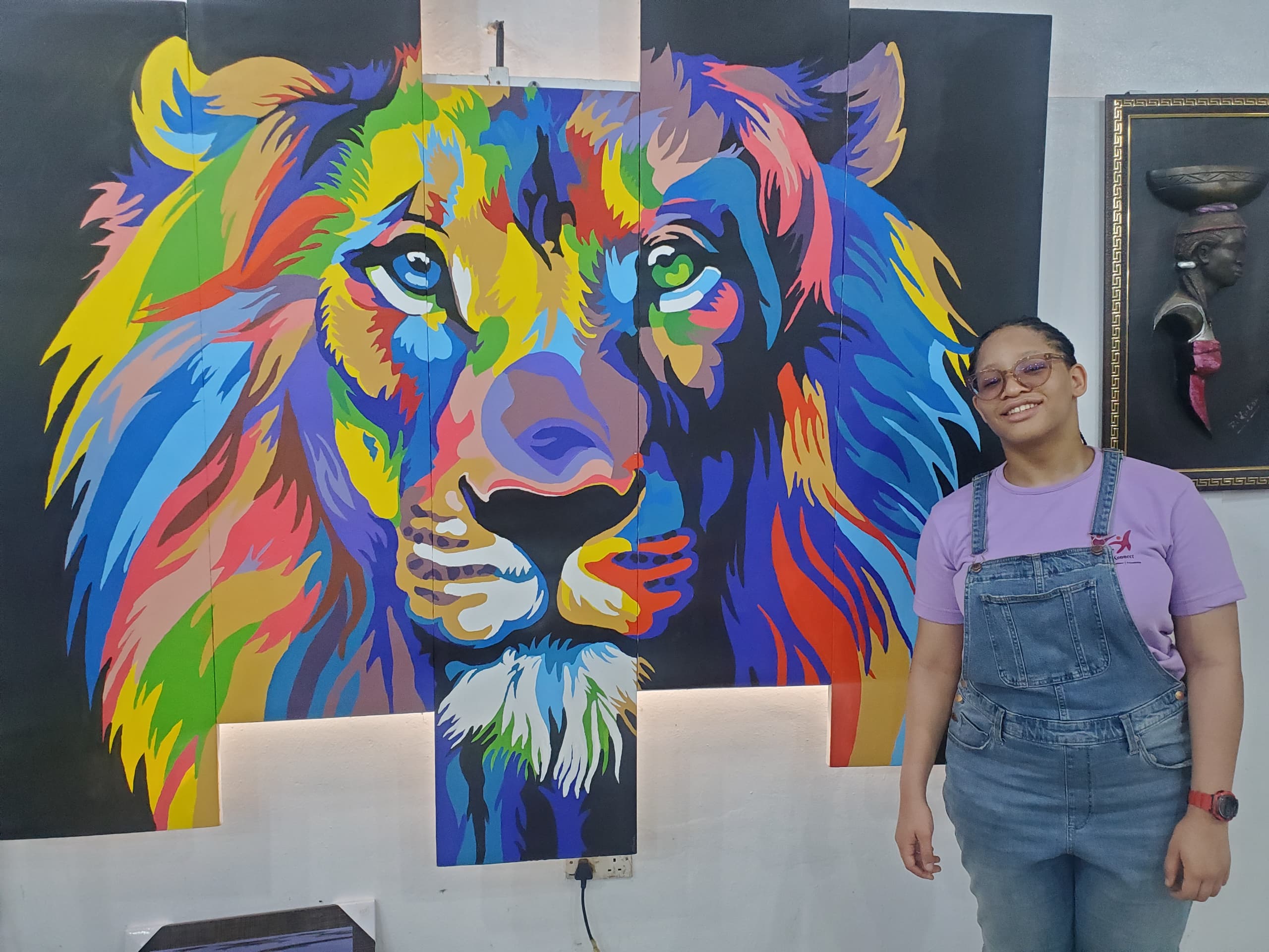 Camper posing with colorful lion mural artwork