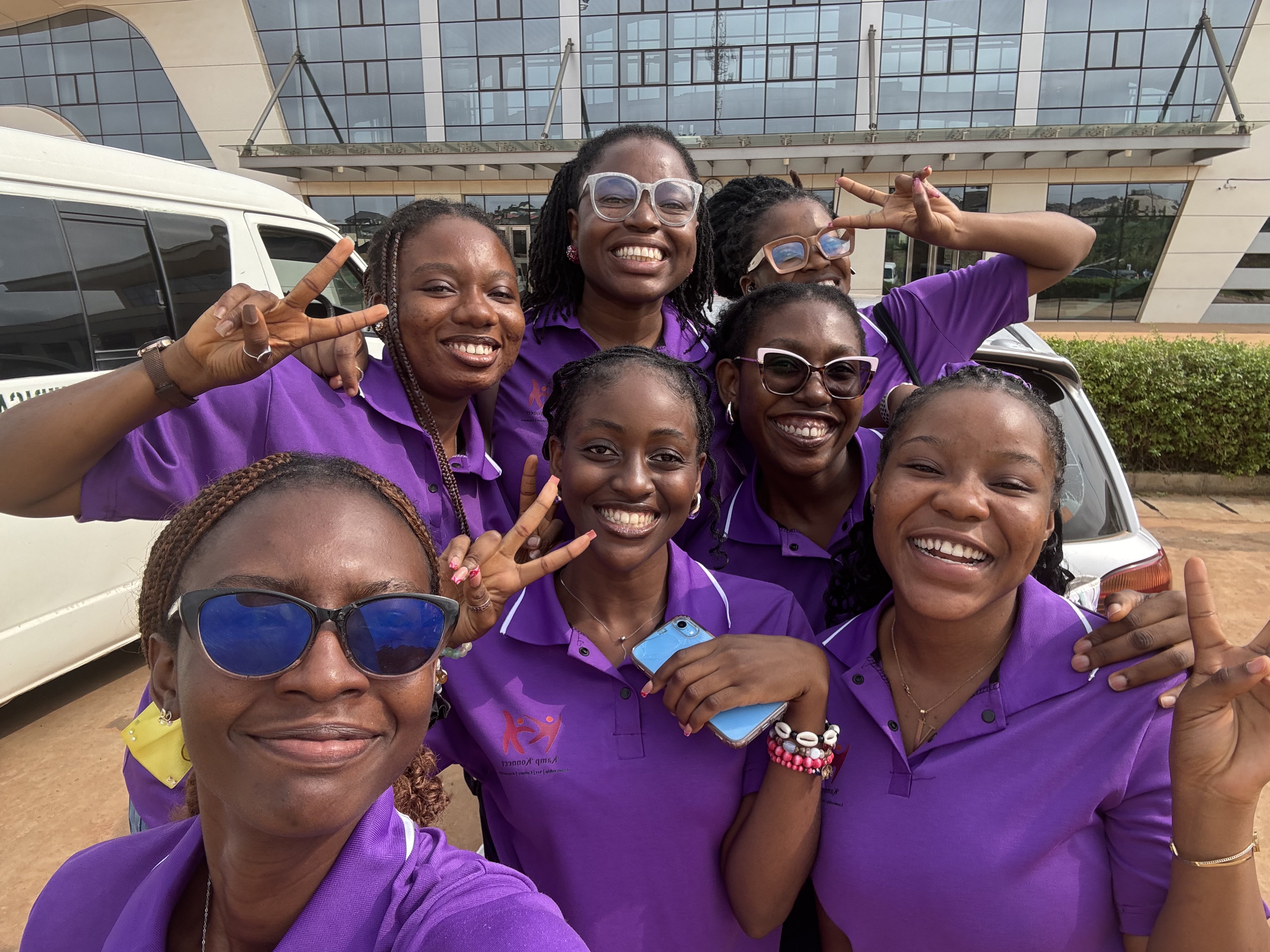 Energetic group of Kamp Konnect volunteers in purple shirts taking a fun selfie together, showing team spirit and camaraderie